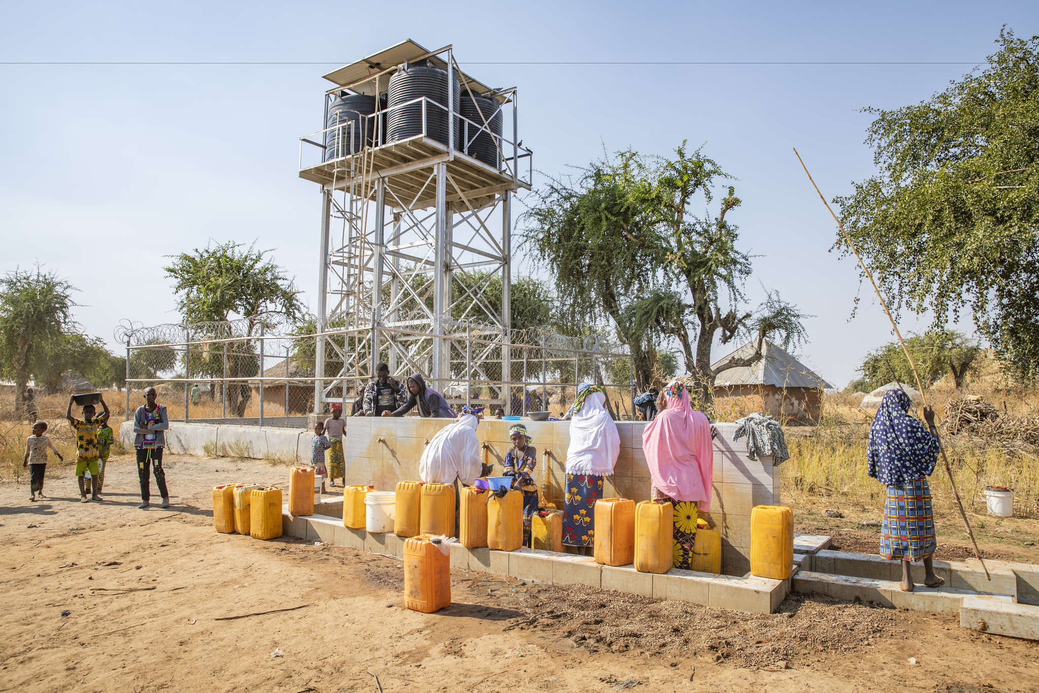 Herders and farmers fill jerrycans from a water point installed by mercy corps.