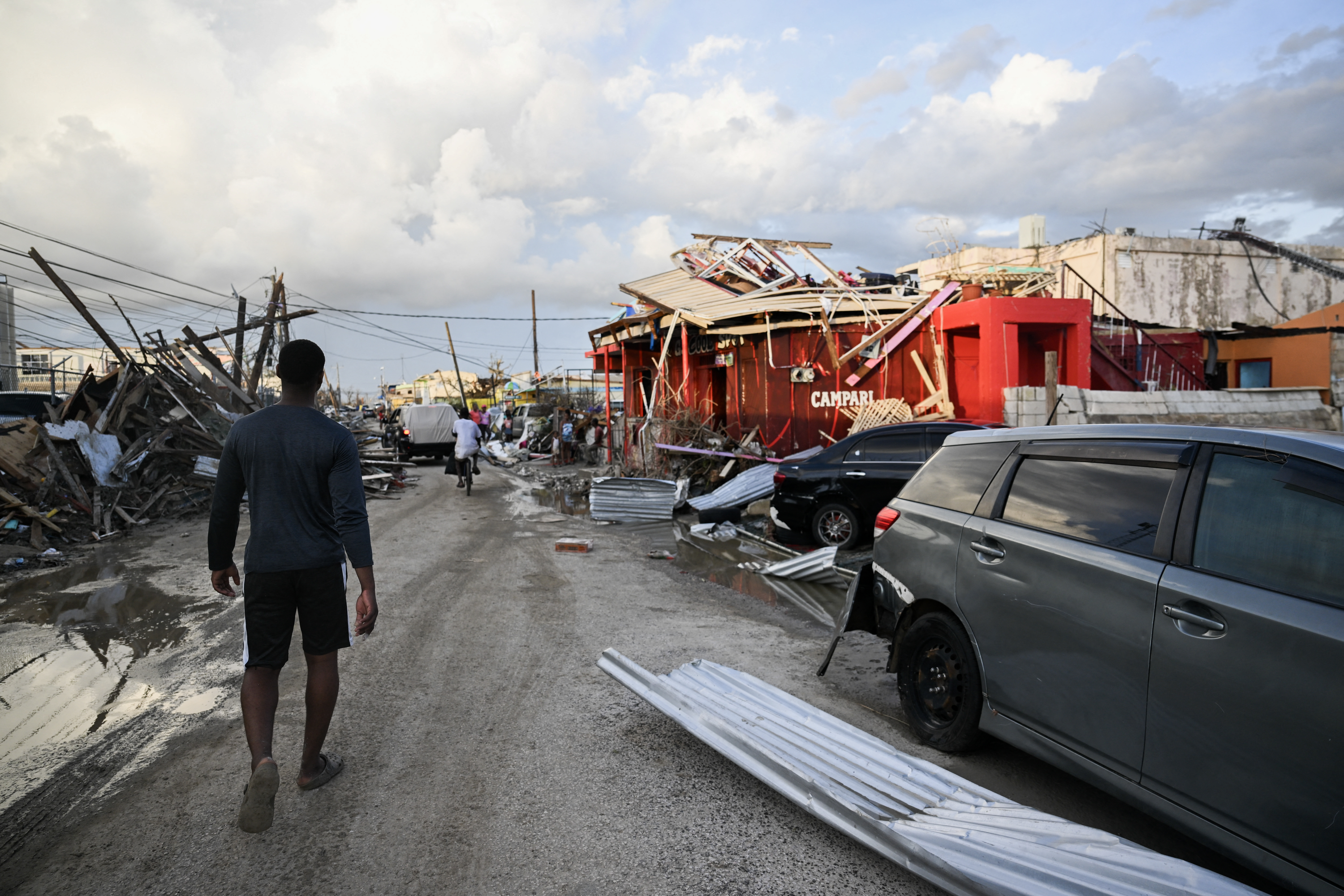 Jamaican walks through street and the hurricane melissa destruction.