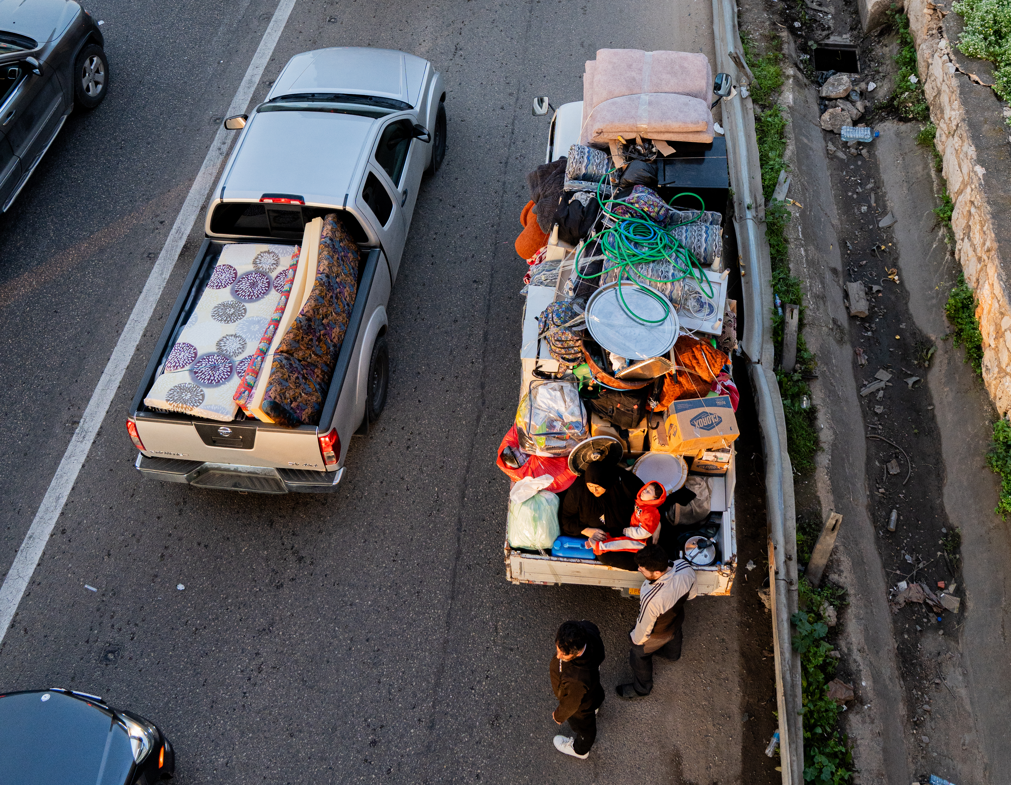 View from above as trucks loaded with personal items are waiting in traffic.