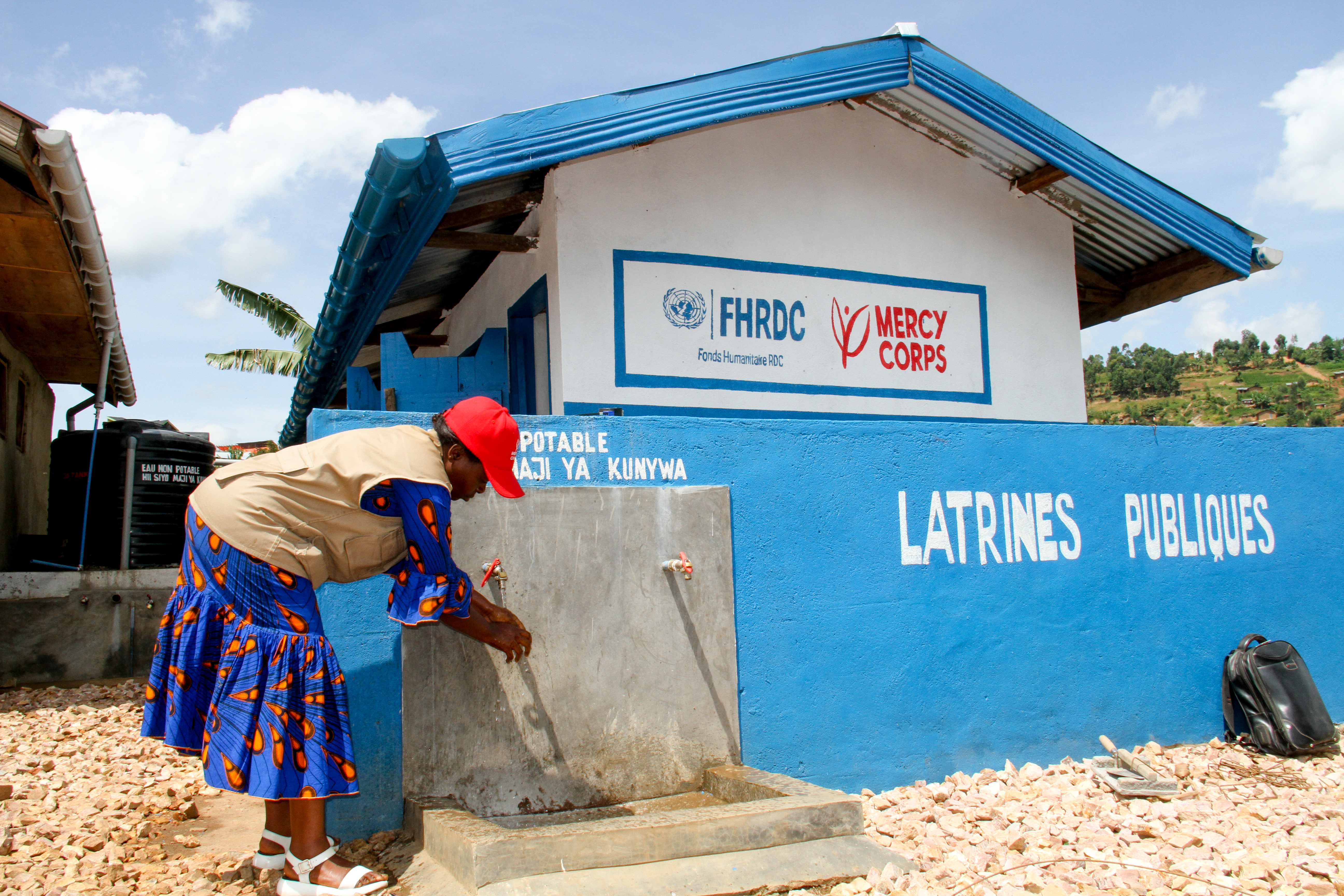 A congolese woman at a water point and latrine in north kivu to strengthen hygiene and prevention.