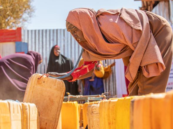 A women collecting water in jerrycans.