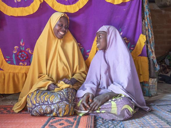 A mother and daughter sitting in their home.