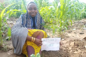 Amina, a young farmer in yobe, plants a tree in her farm.