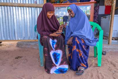 Two women use technology in a community setting.