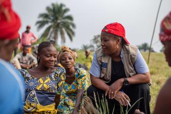 Mercy corps employee speaks with community member.