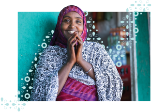 Ethiopian woman smiles with hands clasped.