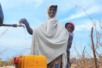 A person filling a jerry can with water.