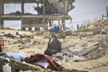 Gaza woman sits amid the ruins of a building.