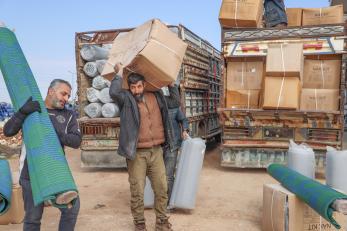 People unloading unloading kits for families affected by the earthquake in northwest syria.