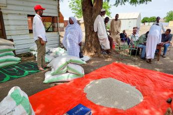 Farmers receiving seeds and fertilizer.