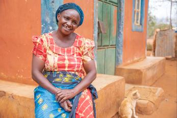 Kenyan woman in front of home.