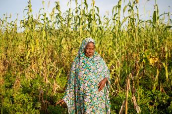 A person standing with their crops in Nigeria. 