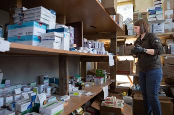 A person in a warehouse pulling medicine to send to people trapped by the war in eastern Ukraine. 