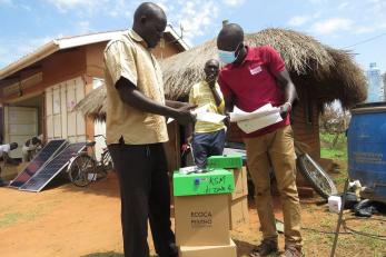 A Mercy Corps member reviewing a participtants paper work in Uganda’s Bidi Bidi refugee settlement.