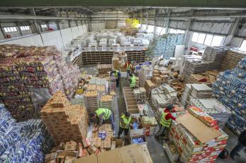 A warehouse with Mercy Corps staff and volunteers packing 1,300 food kits.