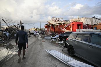 Jamaican walks through street and the Hurricane Melissa destruction.
