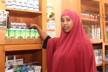 Woman from Horn of Africa displays some products in her Agrovet shop.