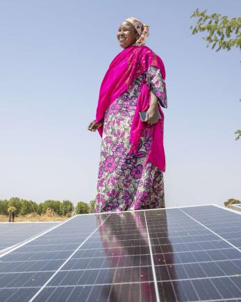 A person standing next to a solar panel.
