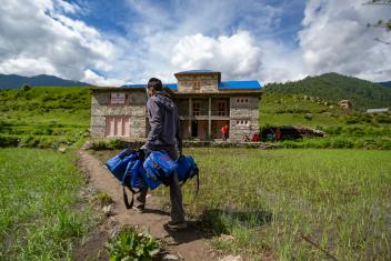 A health worker delivers COVID‑19 kits to an isolation center in Julma, a remote community in Nepal. The kits from Mercy Corps include face masks and shields, hand sanitizer, thermometers, soap, and oximeters.