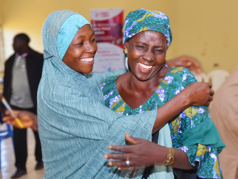 Two people smiling as they share an embrace.