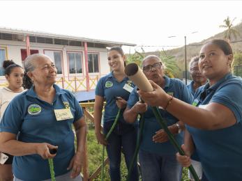 In San Andrés, participants perform a hands-on fire response drill in an emergency preparedness workshop to strengthen community resilience for future disasters. 