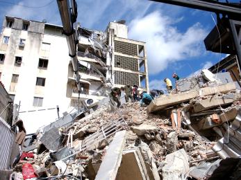 Venezuelan emergency crews work through rubble of building.