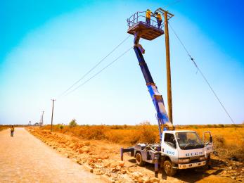 Electrification crew on lift-truck installing power lines outside barwaaqo idp settlement.